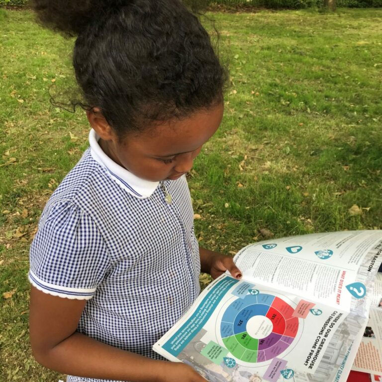 Child looking at community carbon footprint booklet