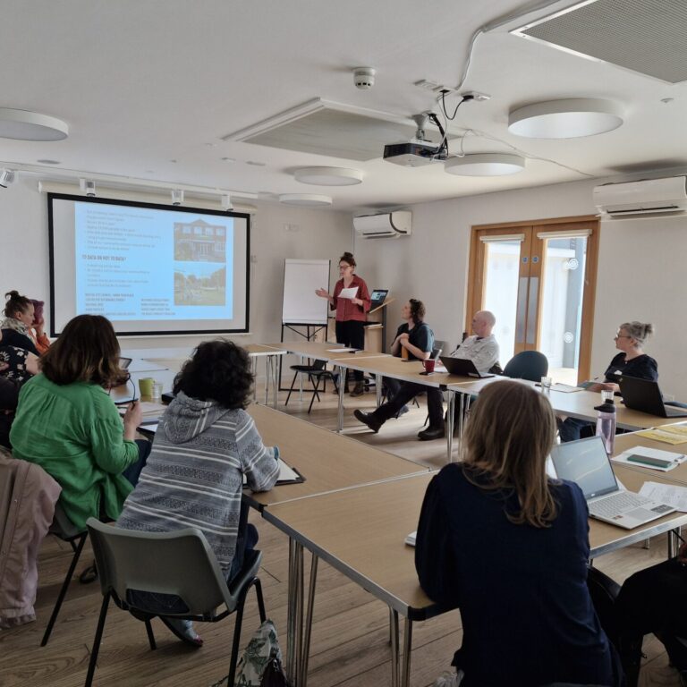 People around a table watching a presentation