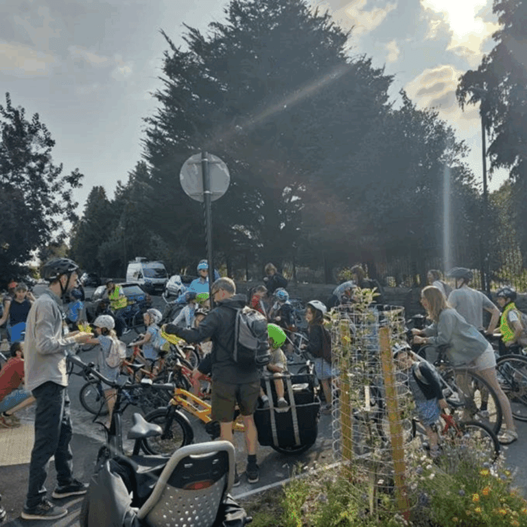 A group of children and adults on bikes at the school gates