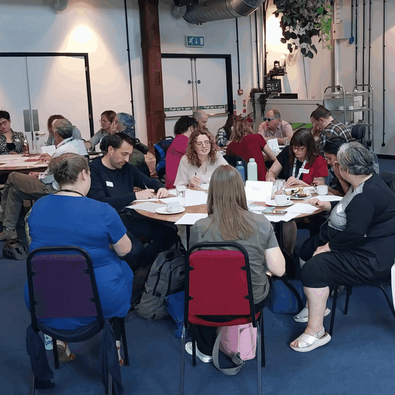 Groups of people sat around tables at an event