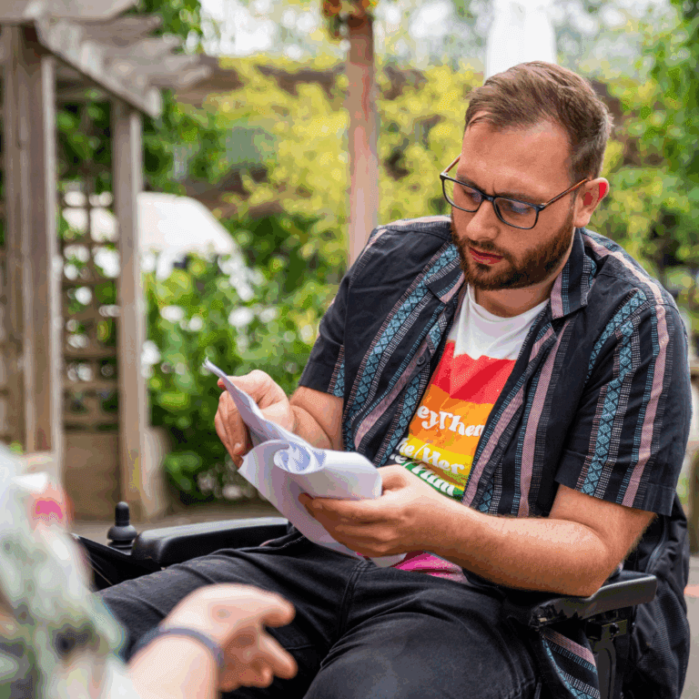 Person in a wheelchair reading a booklet