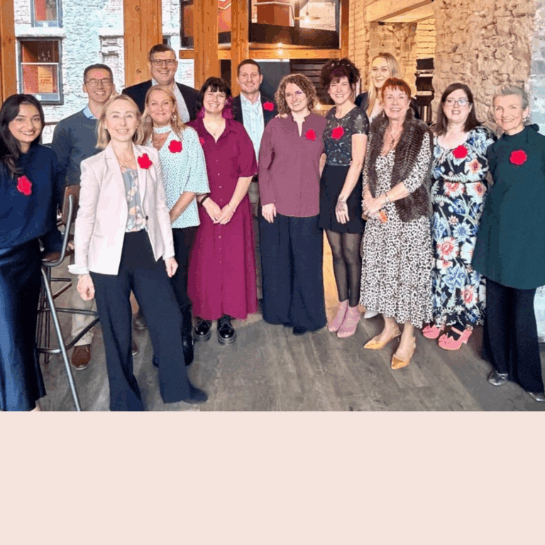 A group of people standing facing the camera and smiling