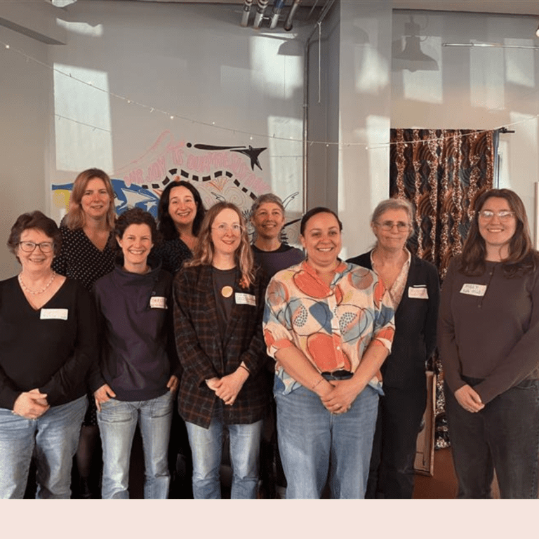 Group of people stood facing camera and smiling