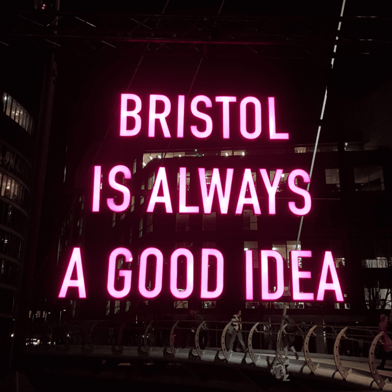 Neon lights above a bridge saying 'Bristol is always a good idea'